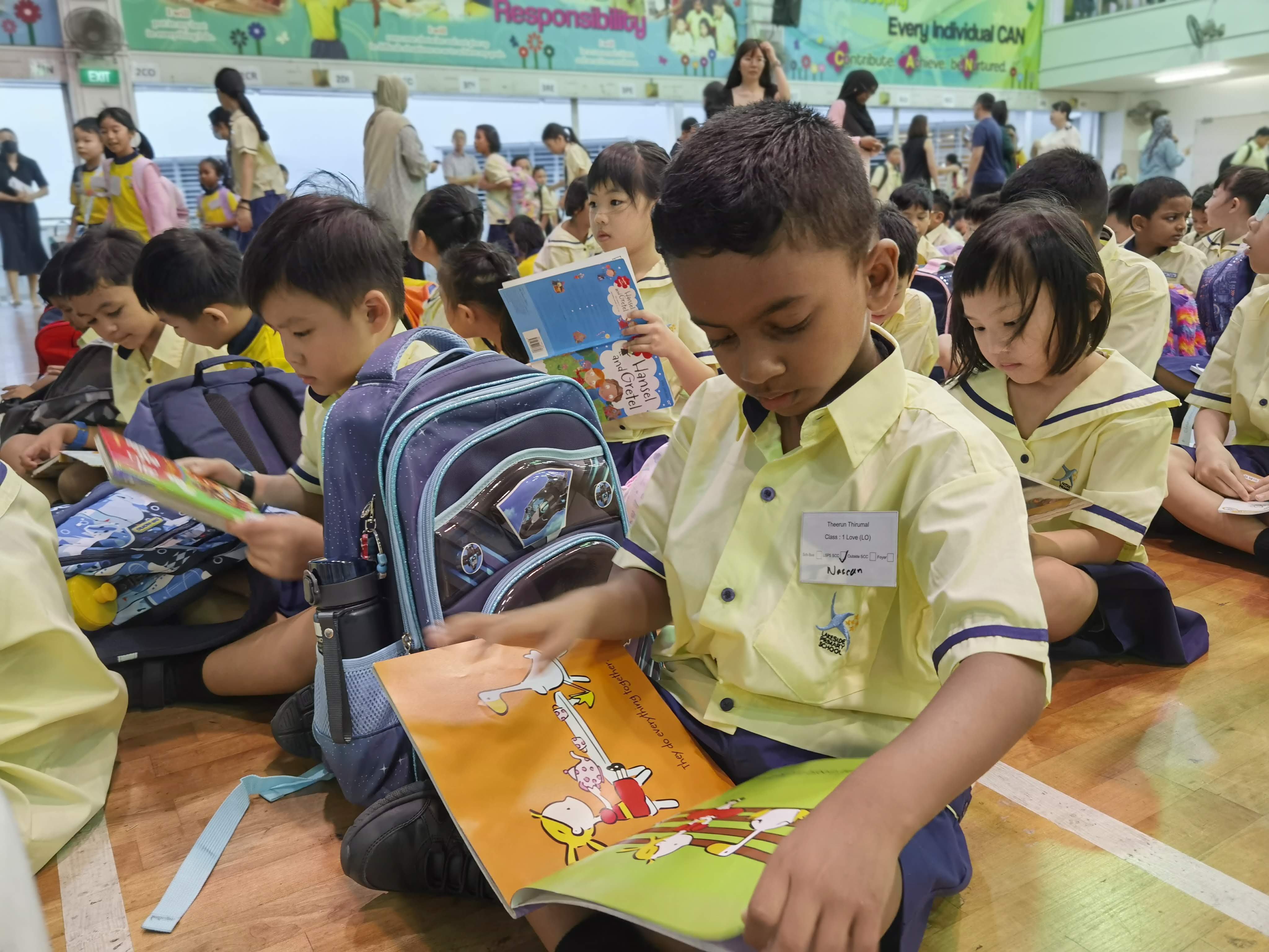 Our primary one students doing silent reading in the hall before morning assembly